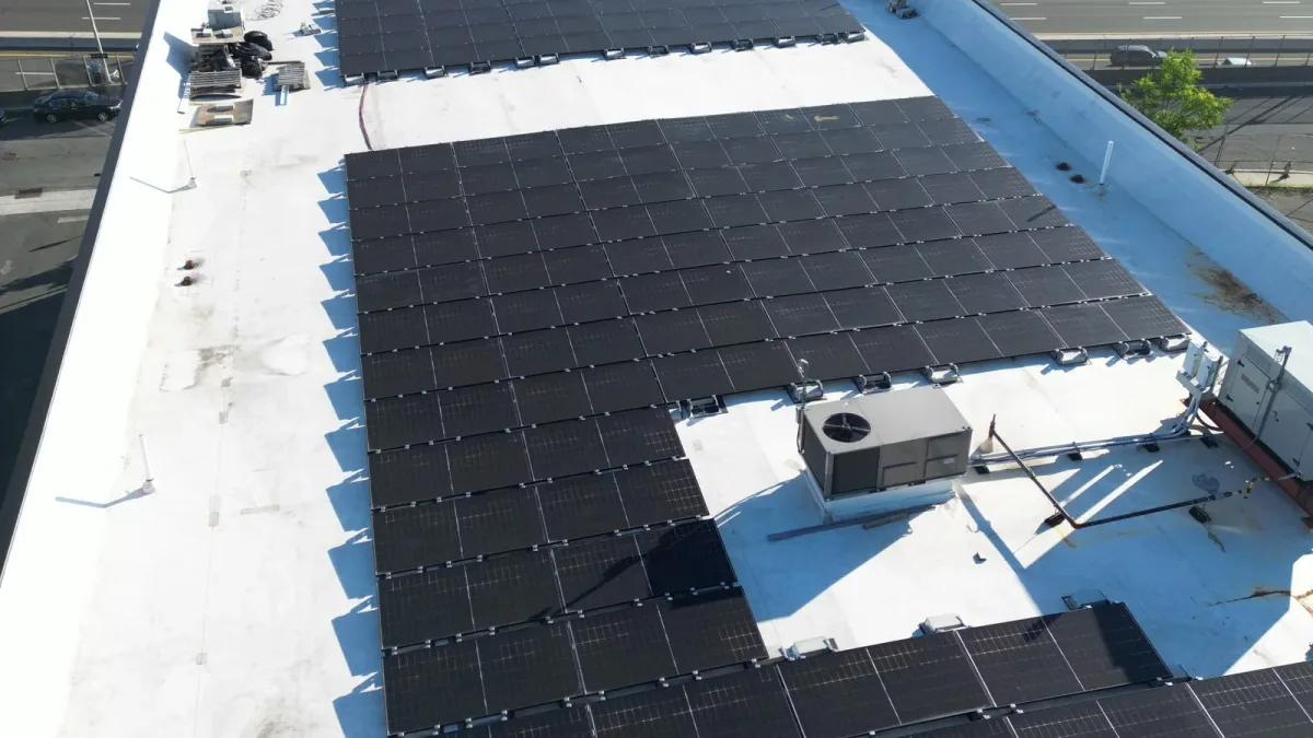 Solar panels and rooftop equipment on a white commercial roof
