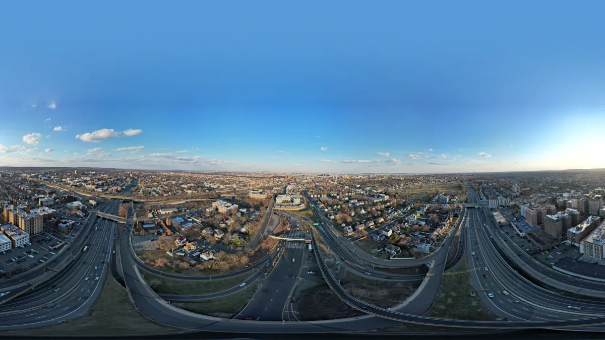 Wide city panorama with highway ramps under a blue evening sky
