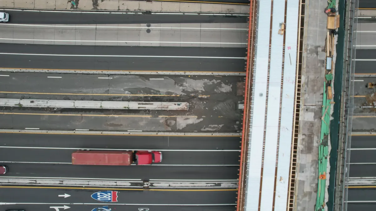 Traffic passing under a bridge under construction in daylight