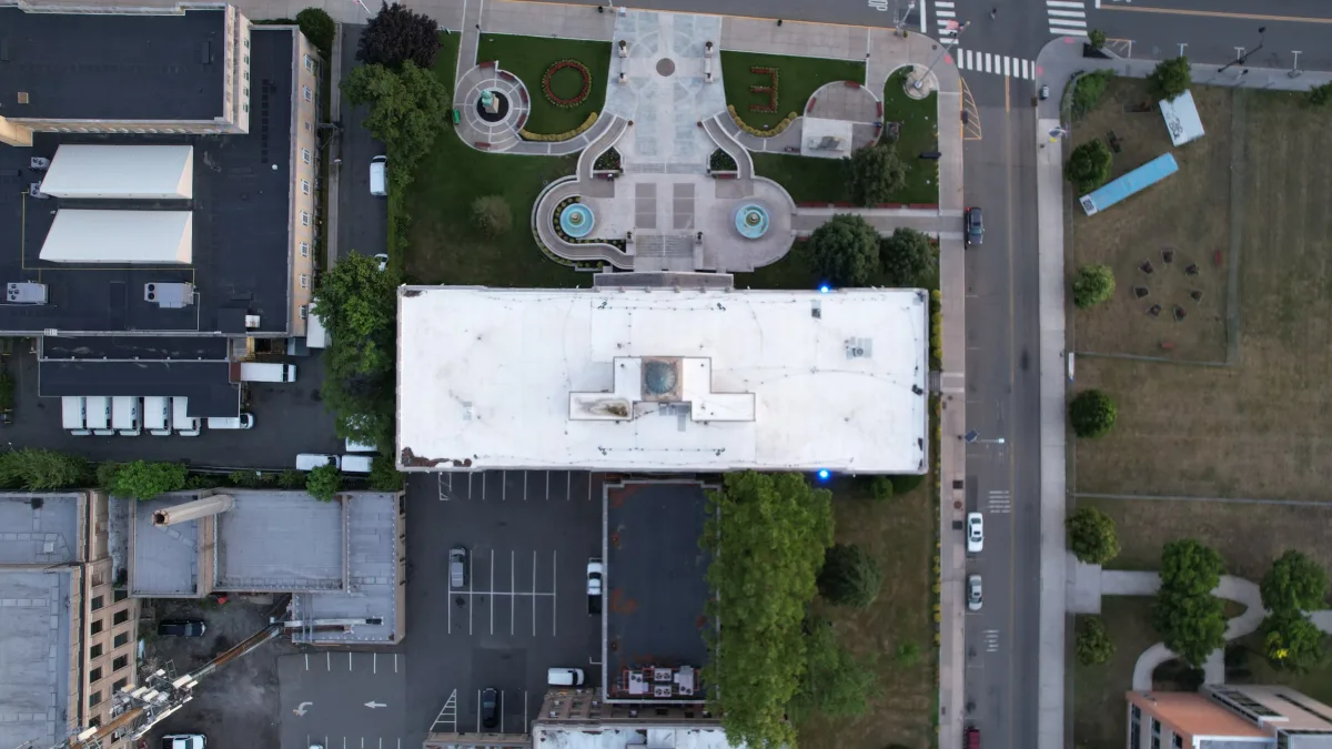 Apartment rooftops and two landscaped courtyards viewed straight down