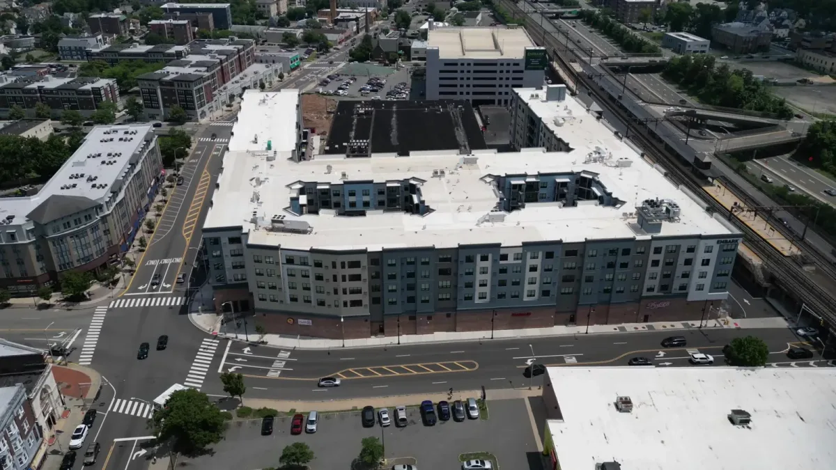 The Crossings apartment roofs, courtyard and parking under daylight