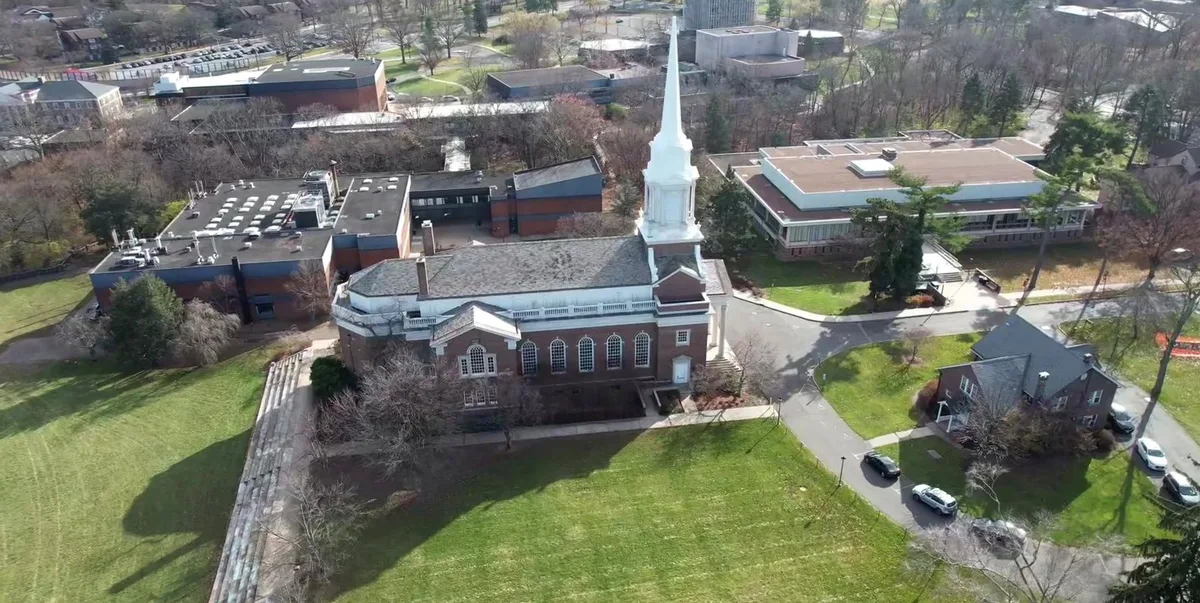 Church, tower, lawn, paths and nearby buildings from above