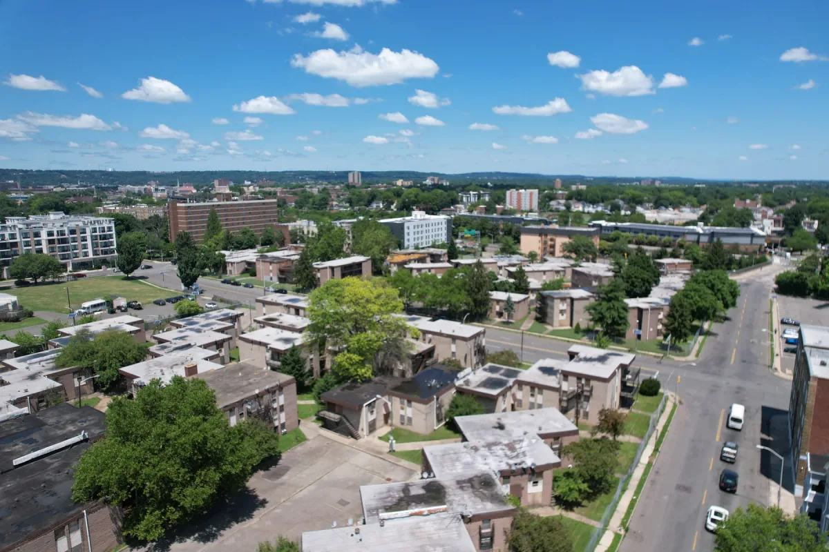 City blocks, trees and buildings under a blue daytime sky