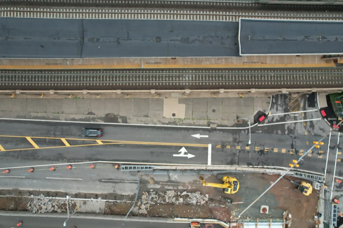 Daylight top-down view of road lanes, railway tracks and a work zone
