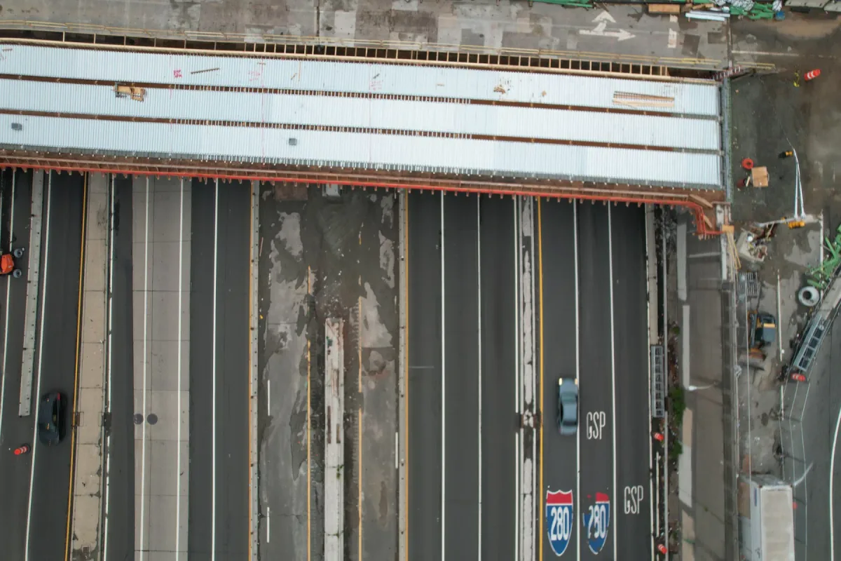 Bridge deck and exposed structure above a highway in daylight